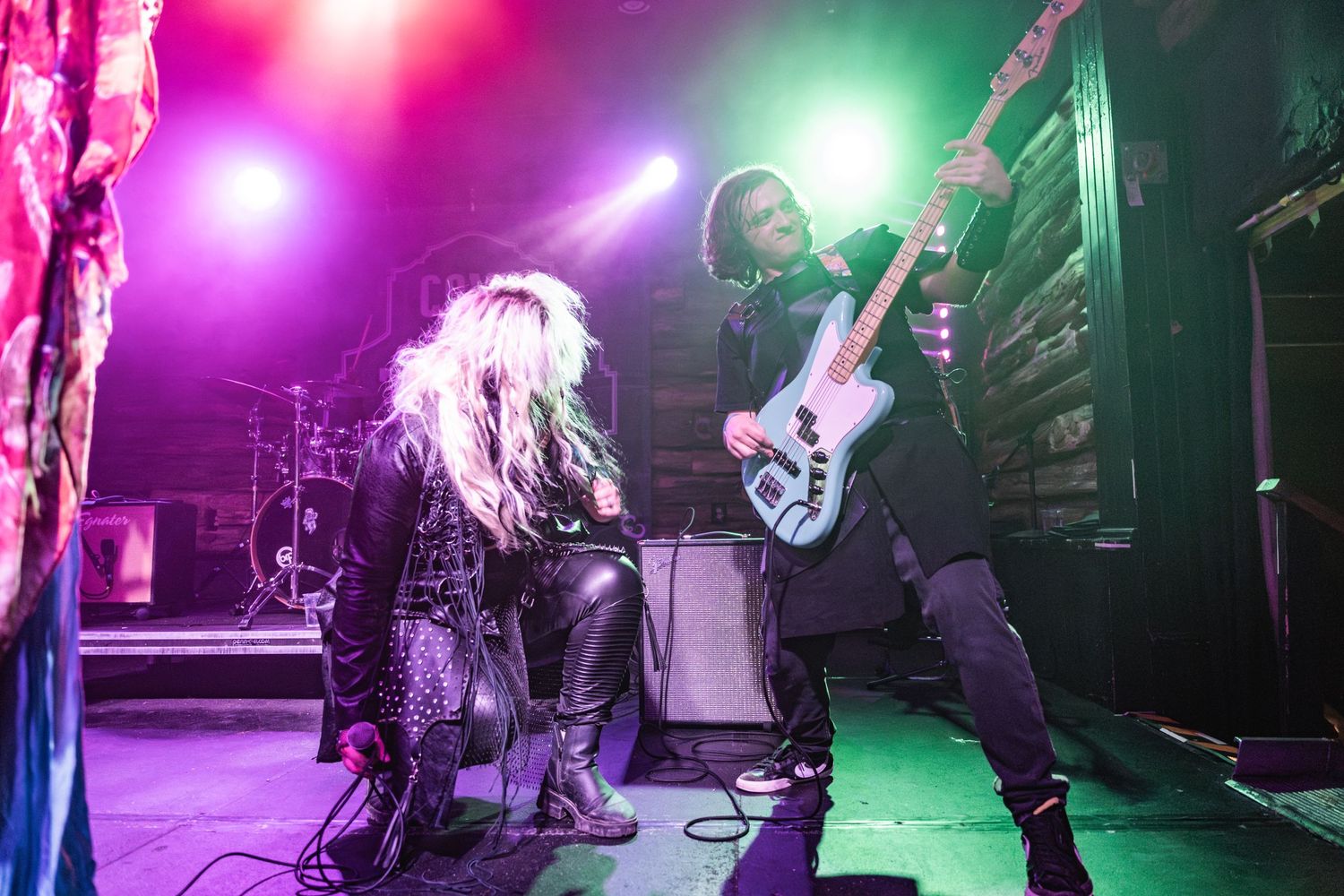 High energy stage performance with vibrant pink and green lighting effects.