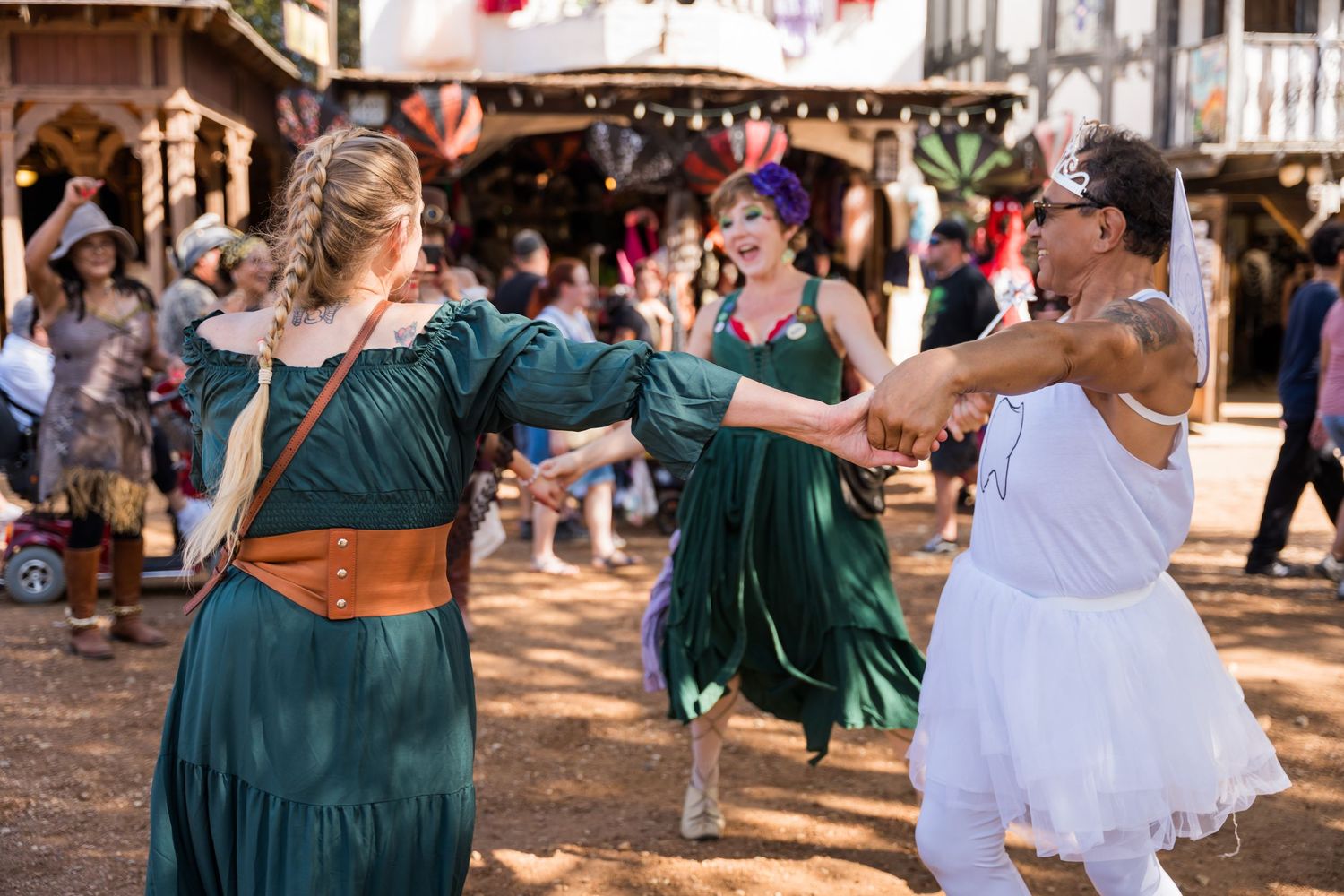 Dancers in medieval costumes perform traditional dances at a renaissance fair.