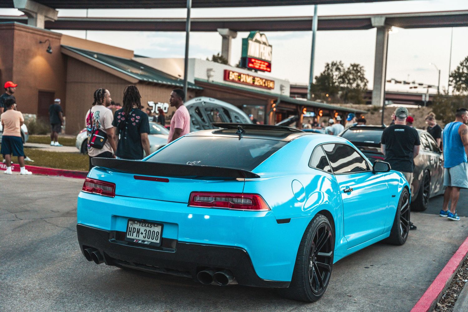 Bright blue Chevrolet Camaro with black wheels parked at car meet.