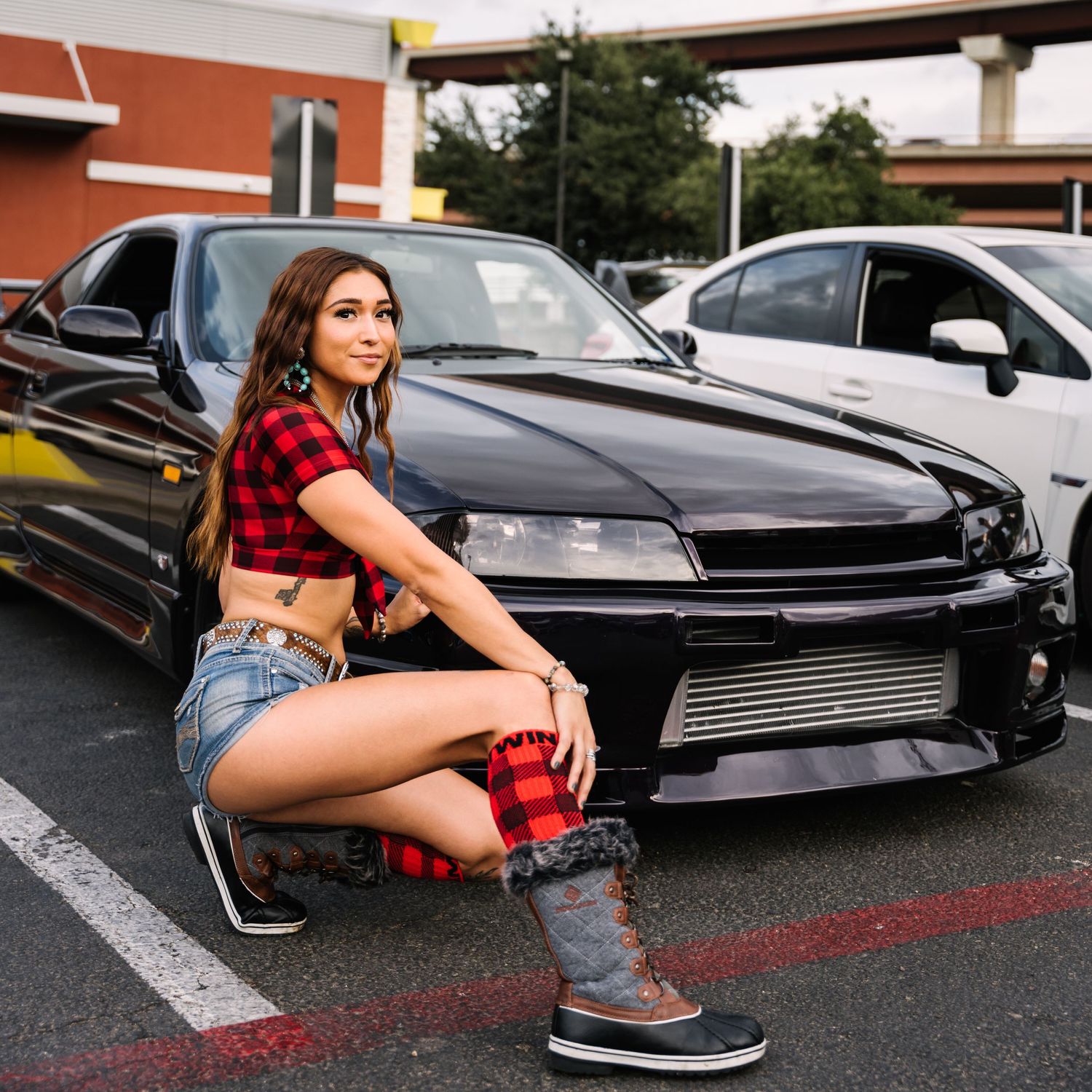 Modified black Nissan Silvia S15 sports car parked in a lot.