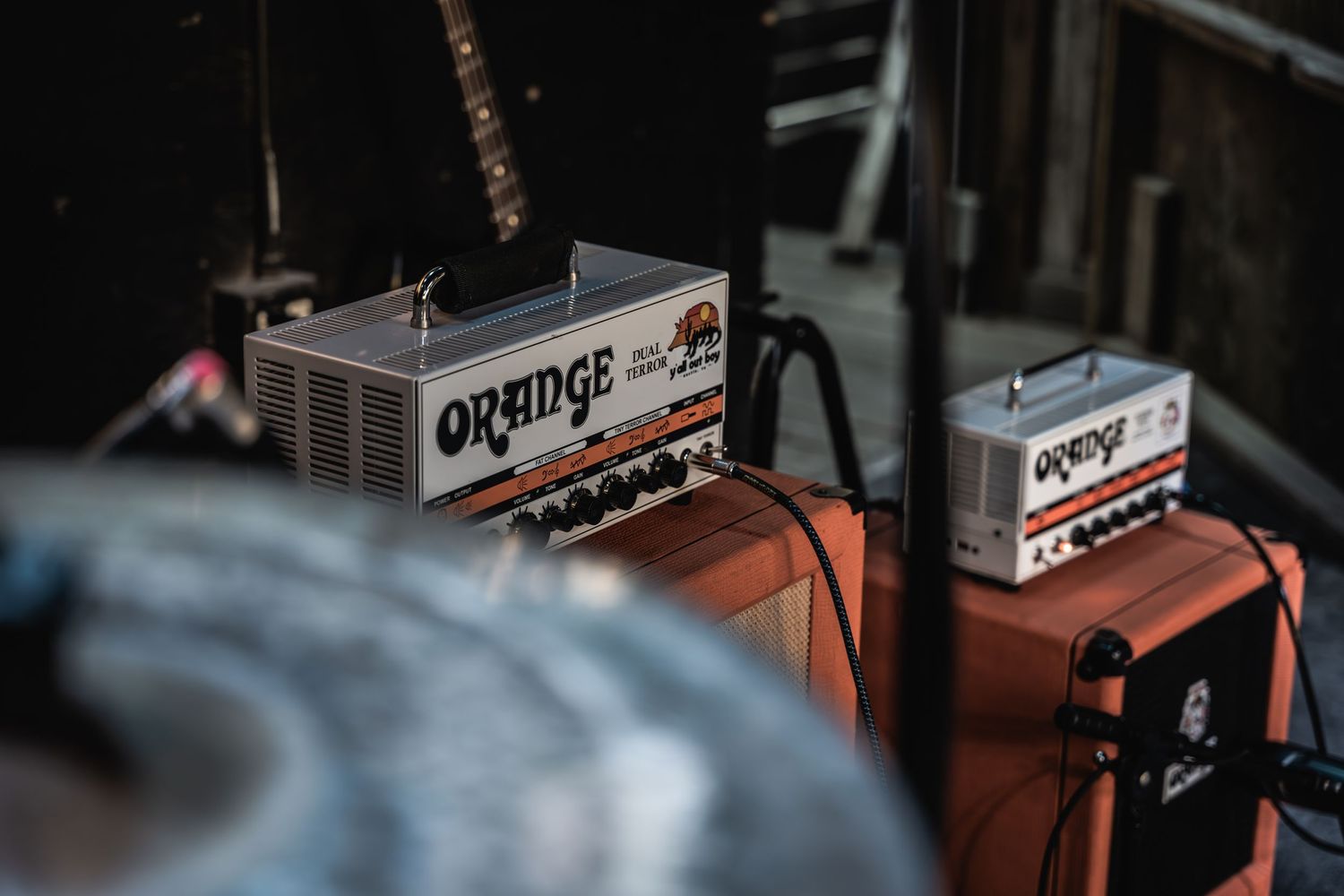 Close up of Orange and NCV guitar amplifiers on stage.