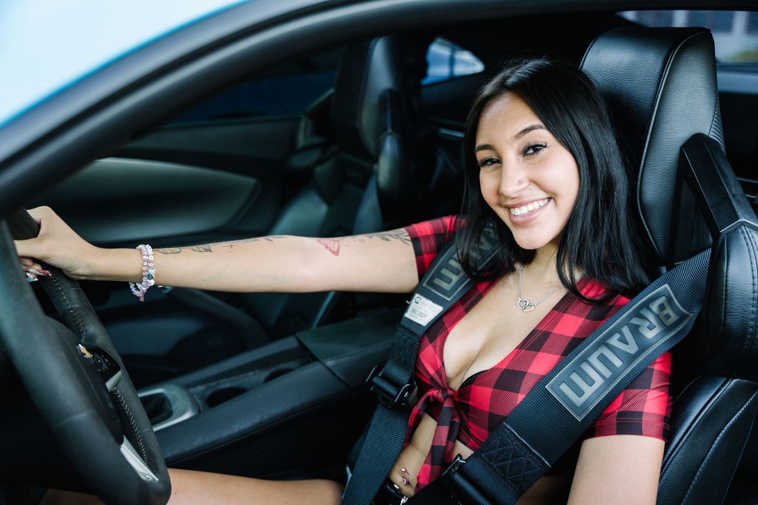 Someone buckled into a racing seat showing off interior details of a performance car.