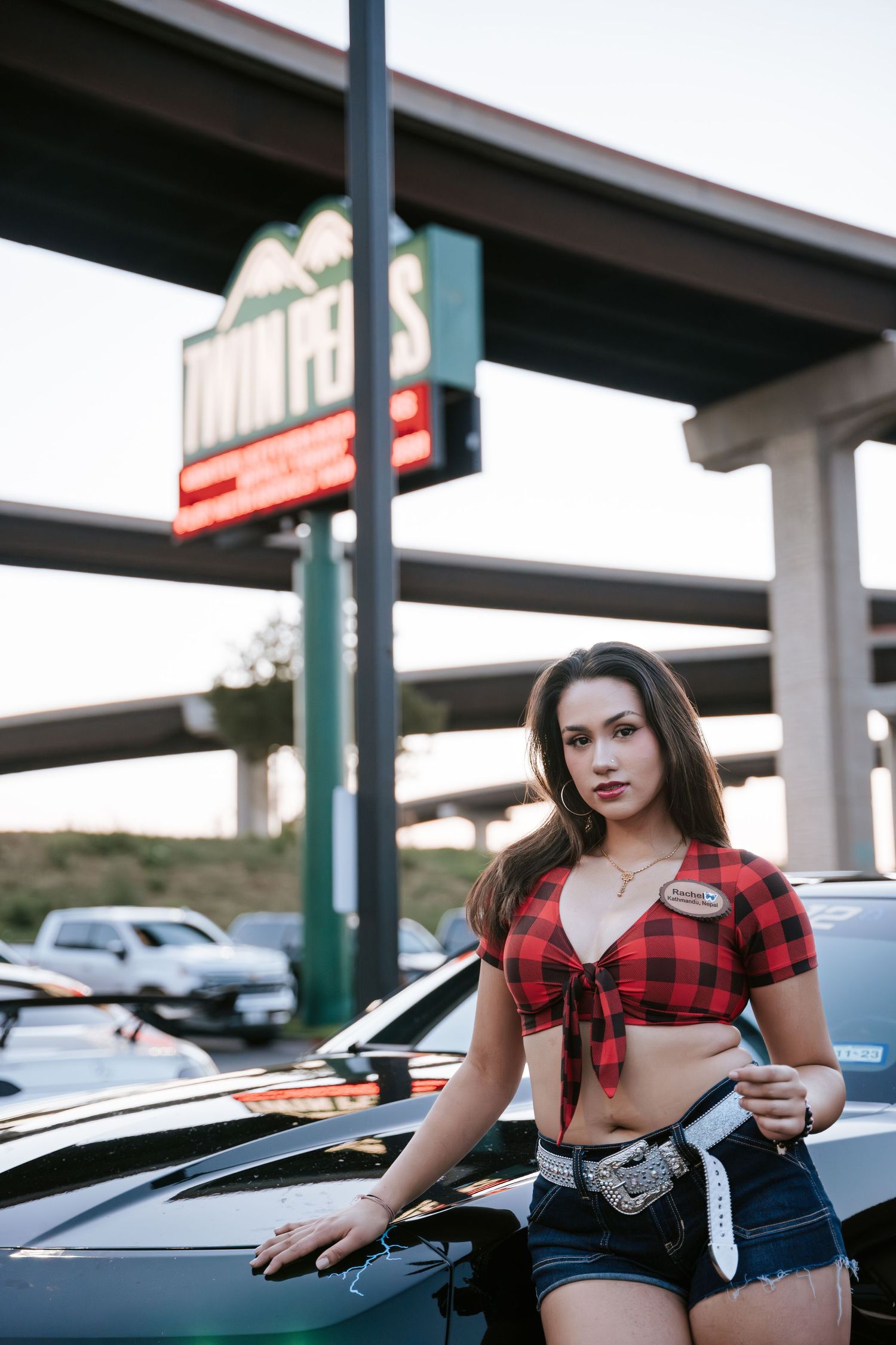 Street fashion portrait with classic plaid and denim style near store signage.
