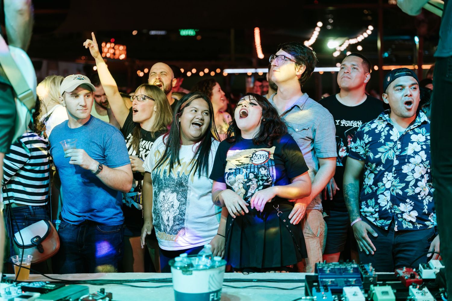 Concert crowd looking up excitedly during live music performance.