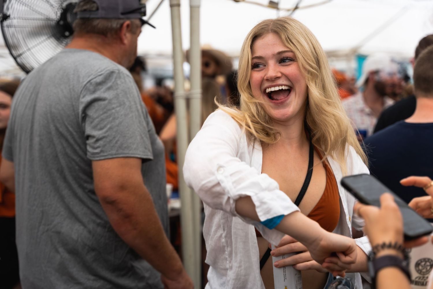 Candid moment of people laughing and socializing at an outdoor summer event.