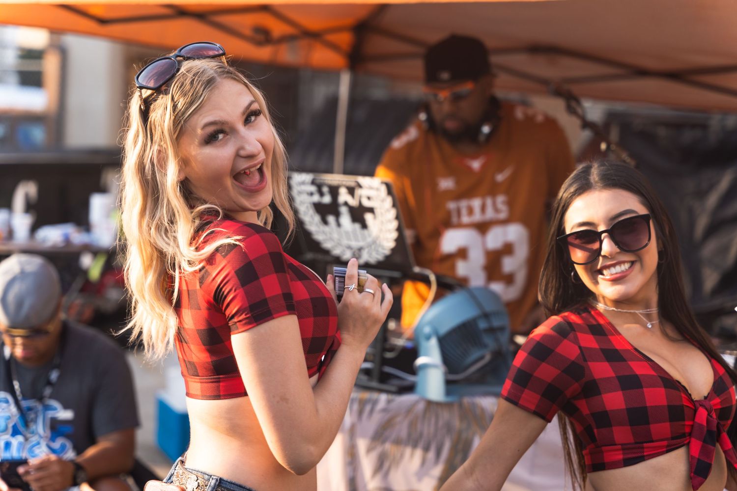 Enthusiastic partygoers in red plaid tops celebrating at an outdoor event.