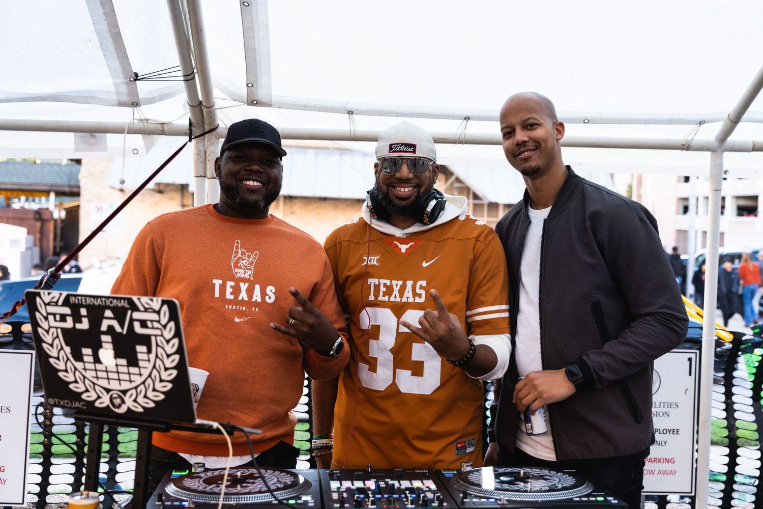 DJs in Texas Longhorns gear perform at an outdoor event.