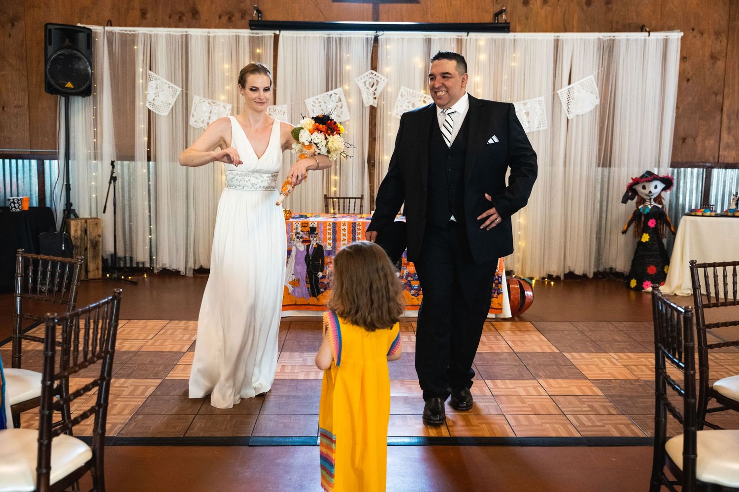 A sweet moment during a wedding reception as a child in yellow interacts with the newlyweds.