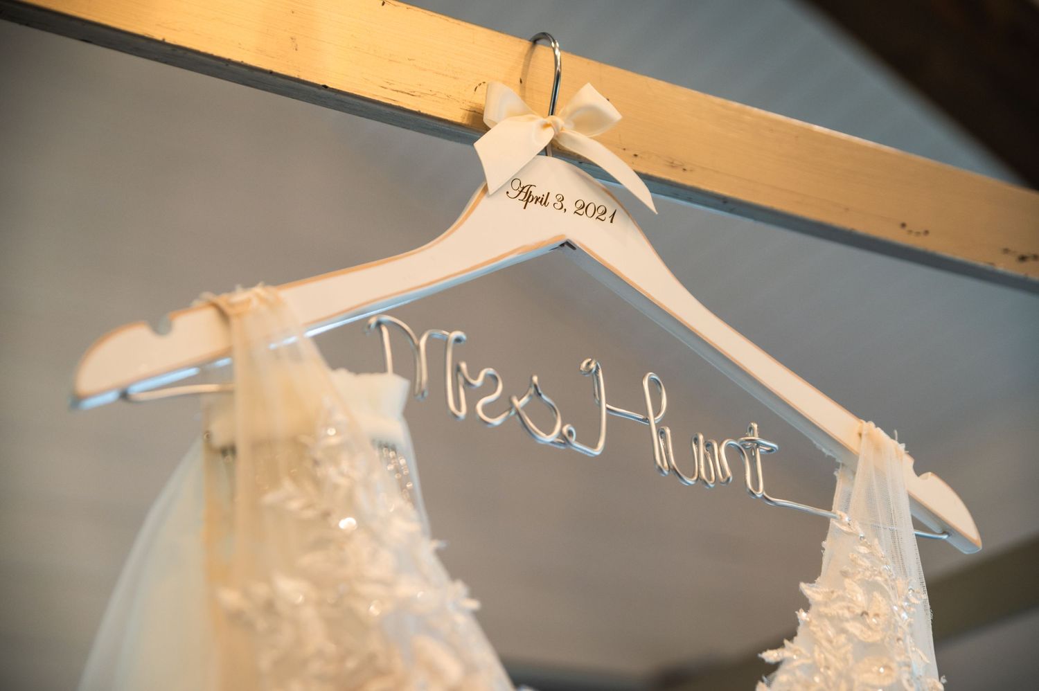 Custom wedding dress hanger with personalized name written in white wire.
