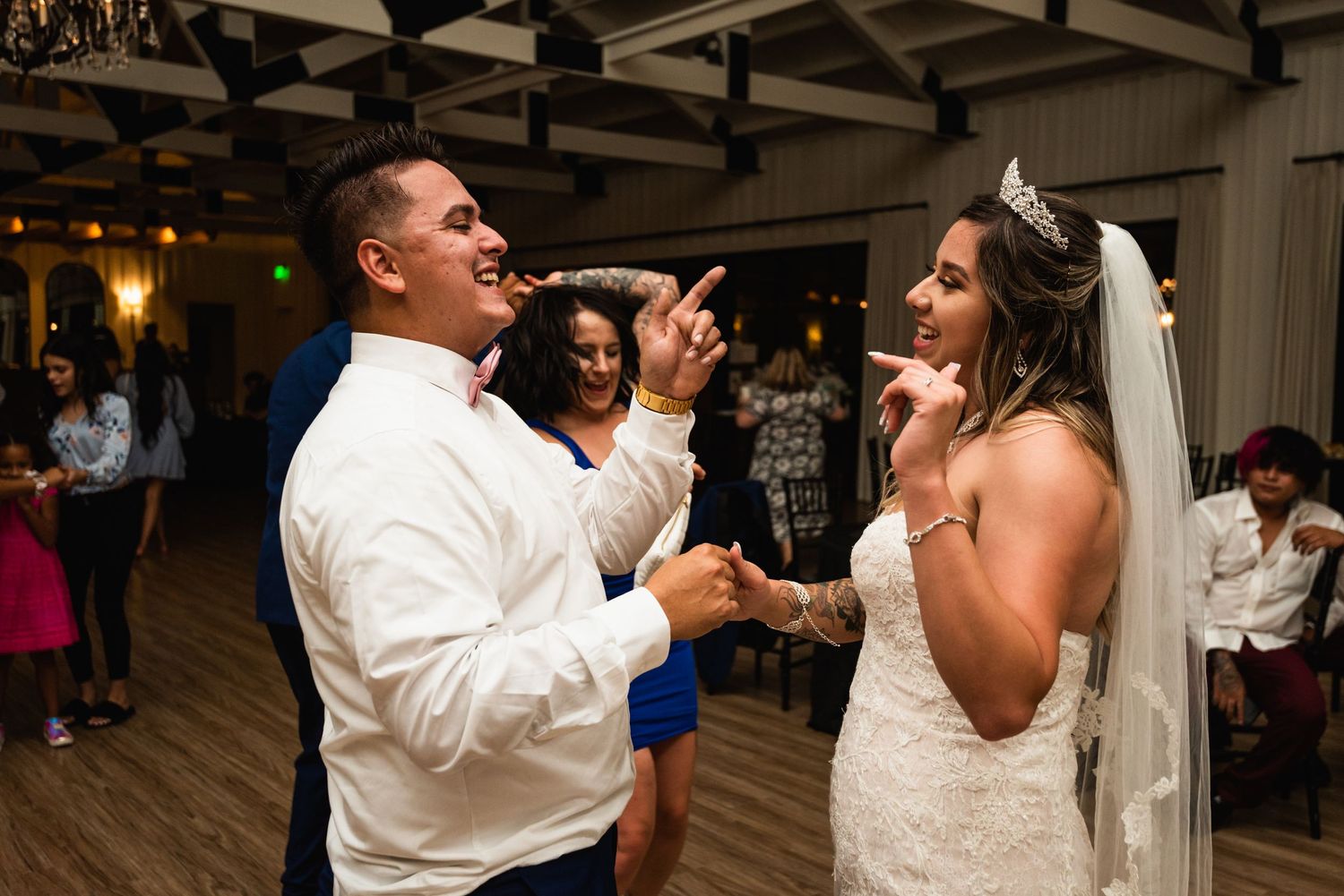 Lively moment on wedding dance floor with guests sharing excited expressions.