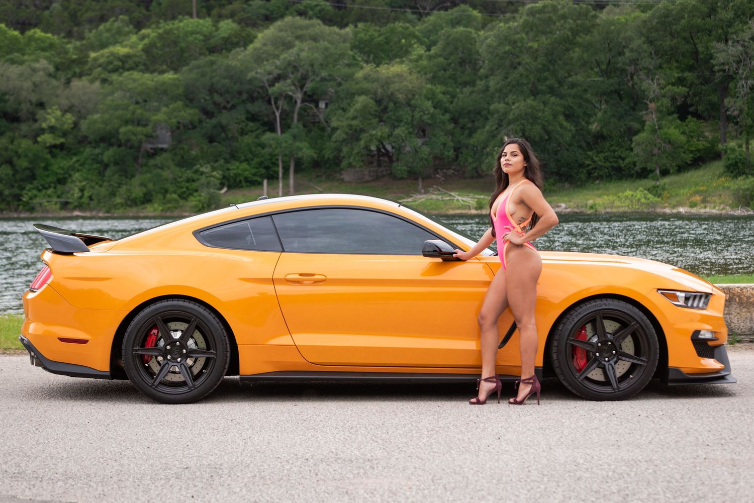 Yellow Mustang Shelby GT350 showcased in profile view near a scenic waterfront.