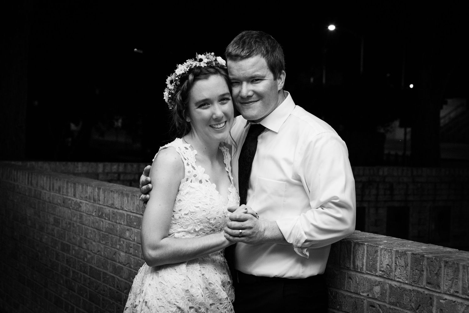 A romantic black and white moment captured outside during a wedding reception.