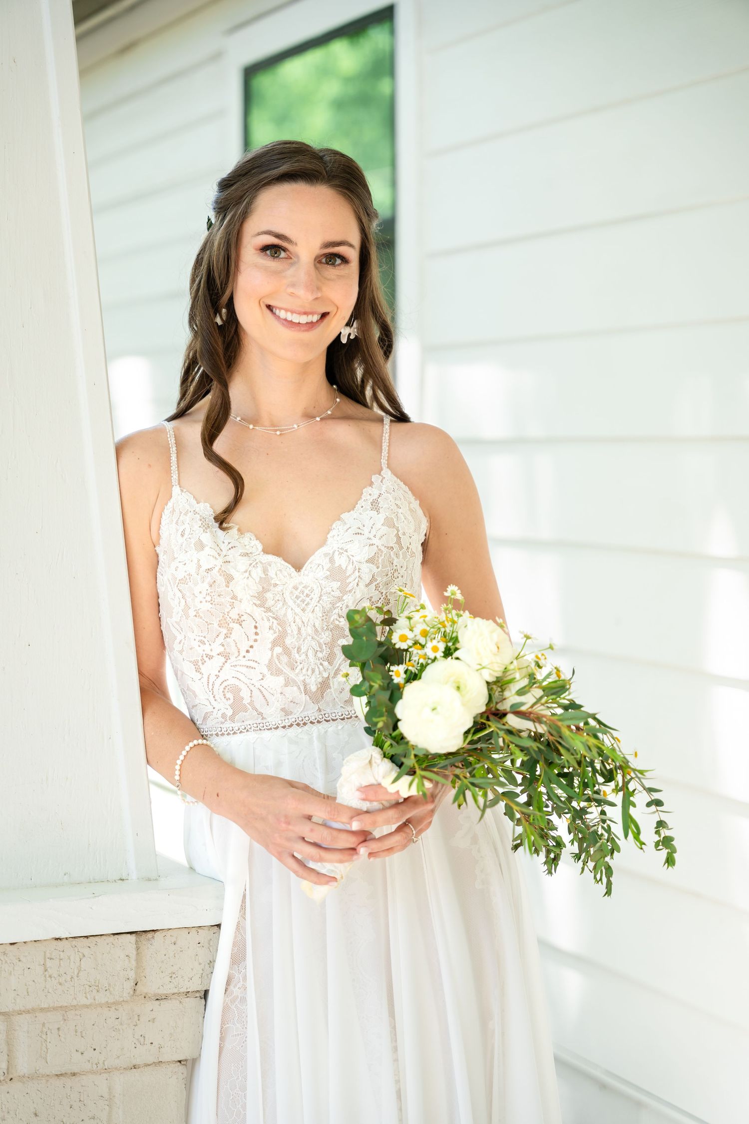 A wedding dress with delicate lace details and a flowing white gown paired with a natural bouquet.