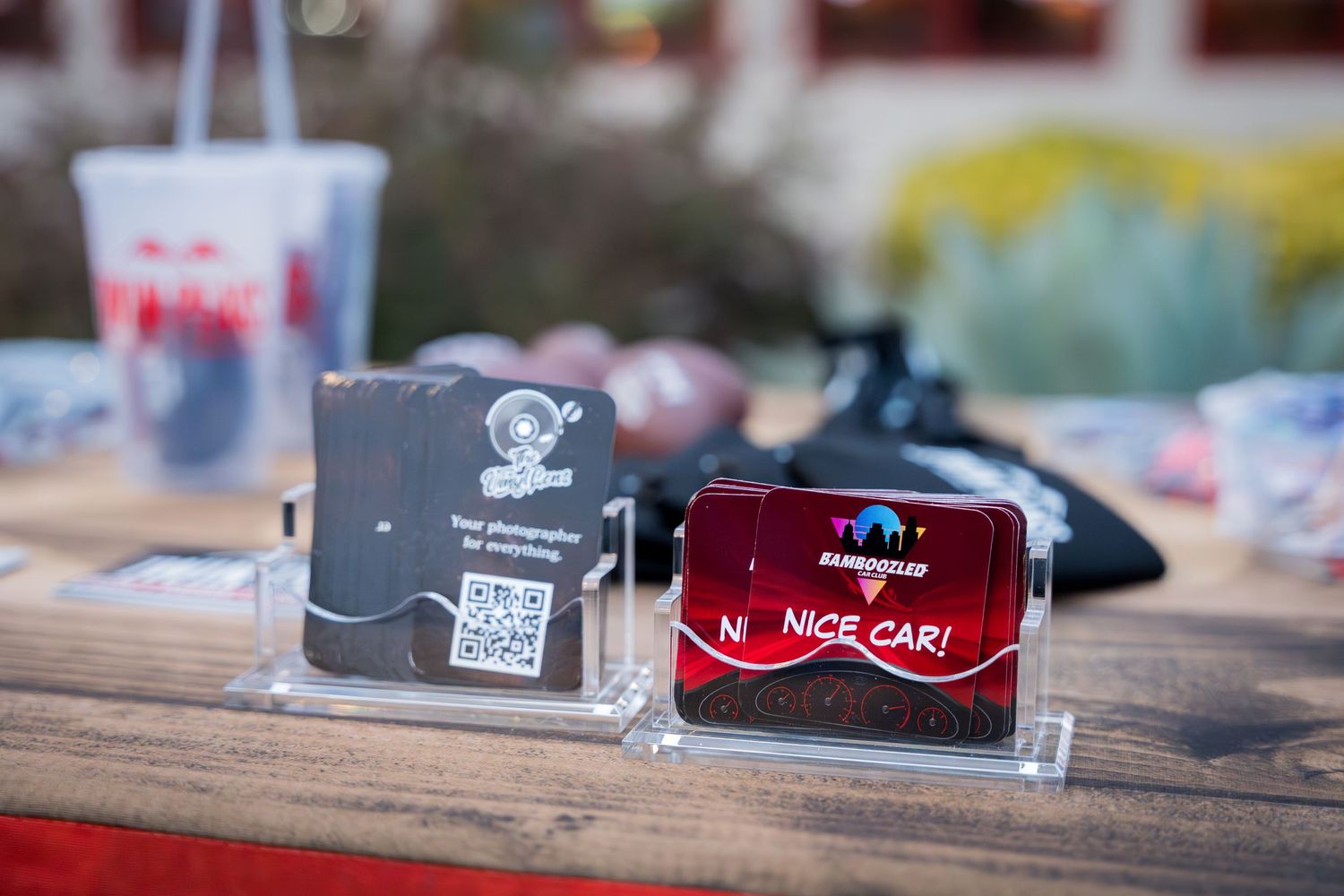 Two promotional drink coasters on wooden table at restaurant.