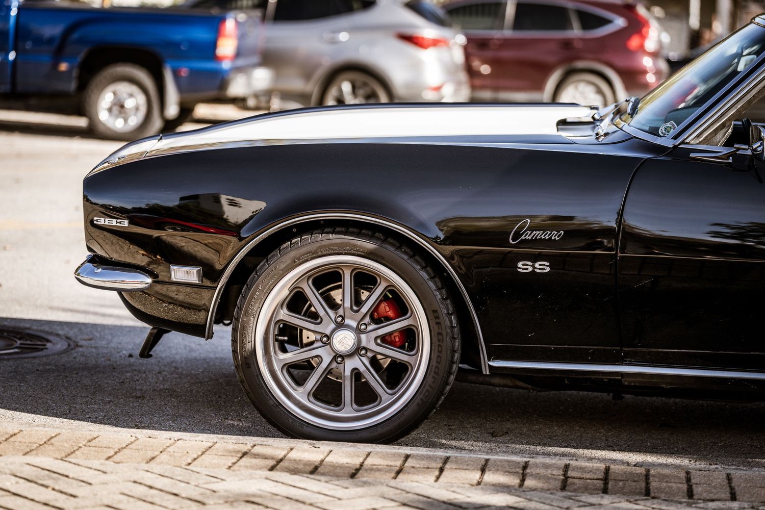 Side view of a classic Chevrolet Camaro showing custom wheels and brake caliper.
