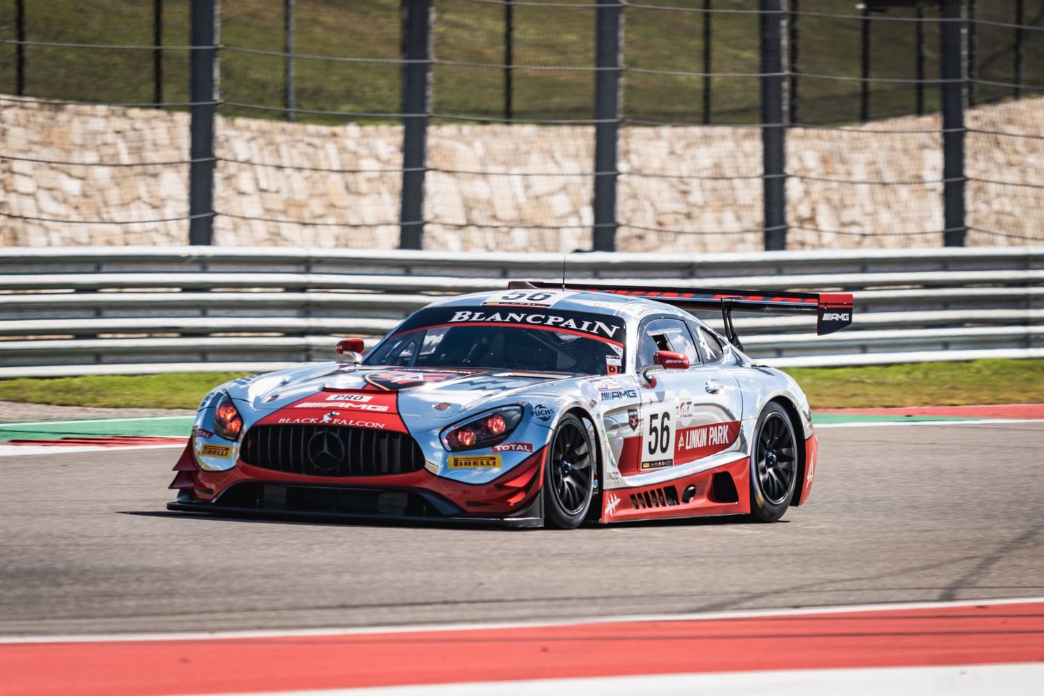Mercedes-AMG GT3 race car takes on a corner at a professional racing circuit.