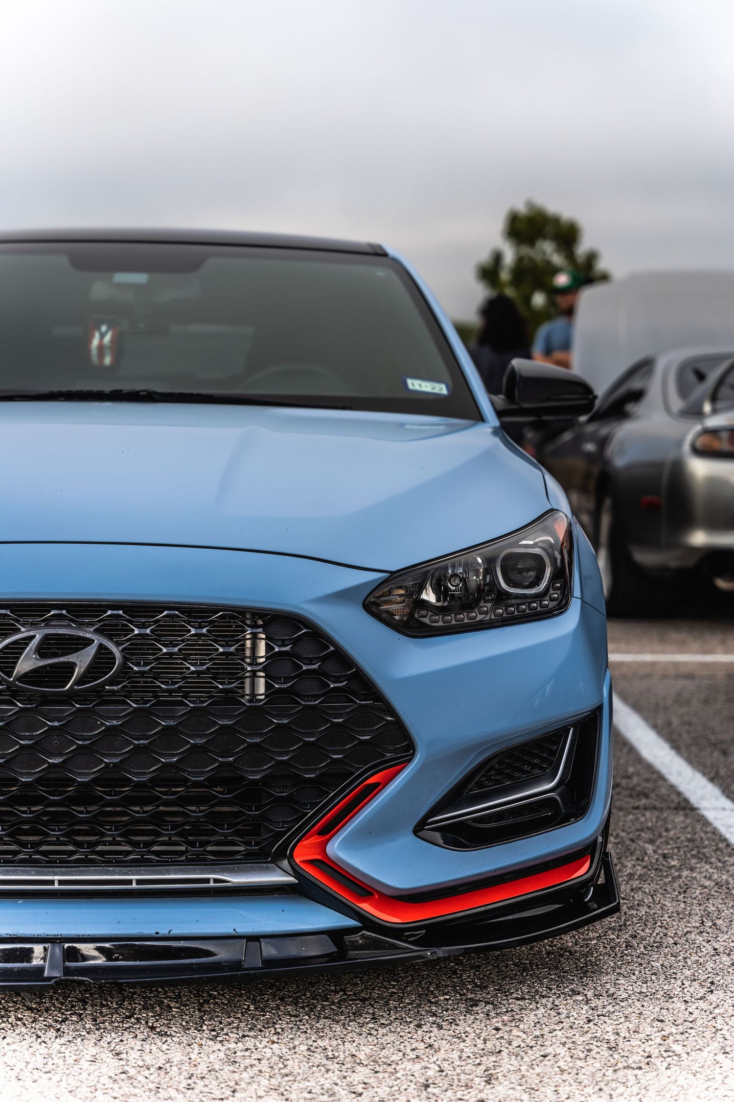 Front view of light blue Hyundai Veloster N with aggressive styling and red accents.