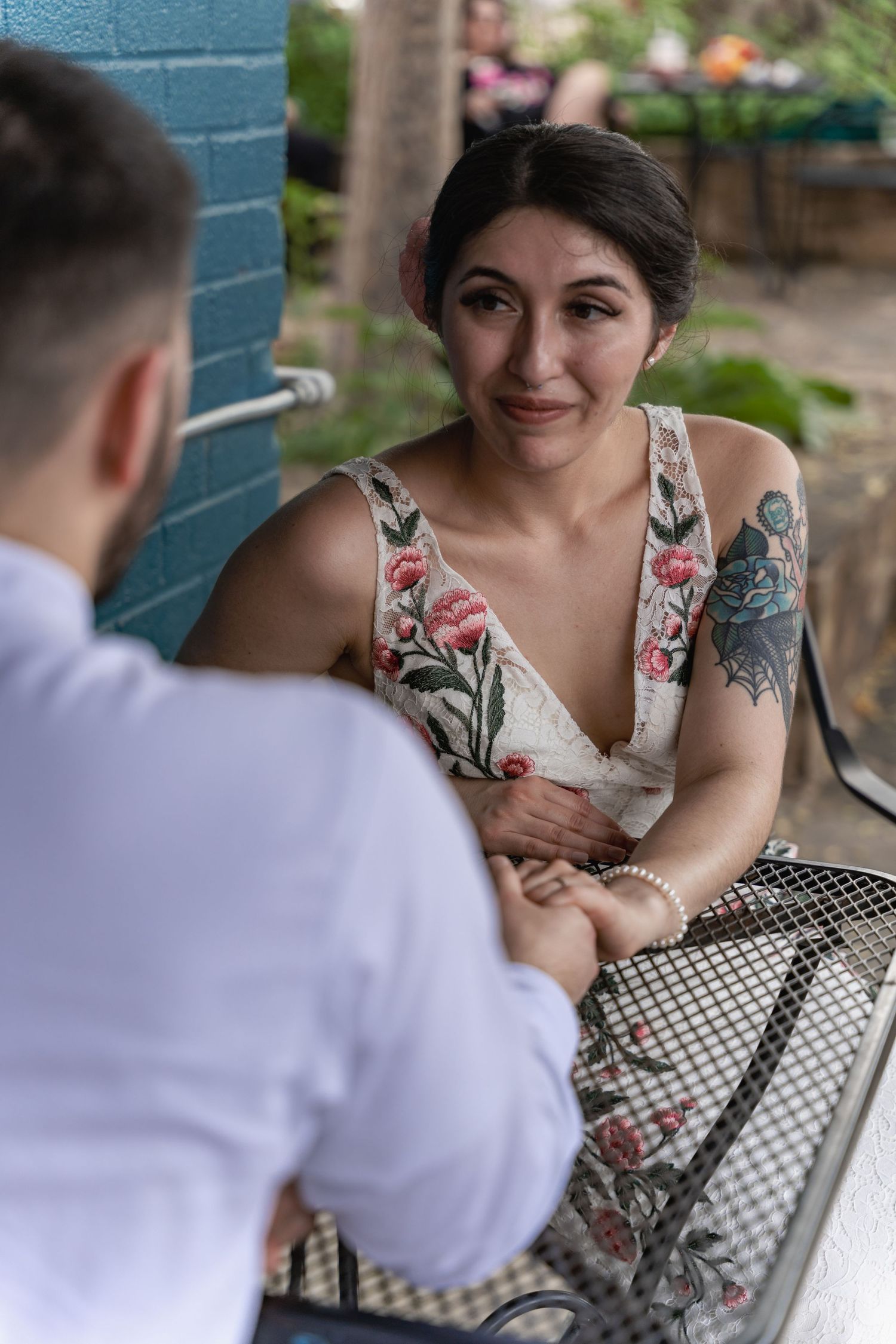 An intimate conversation between two people at an outdoor cafe table.