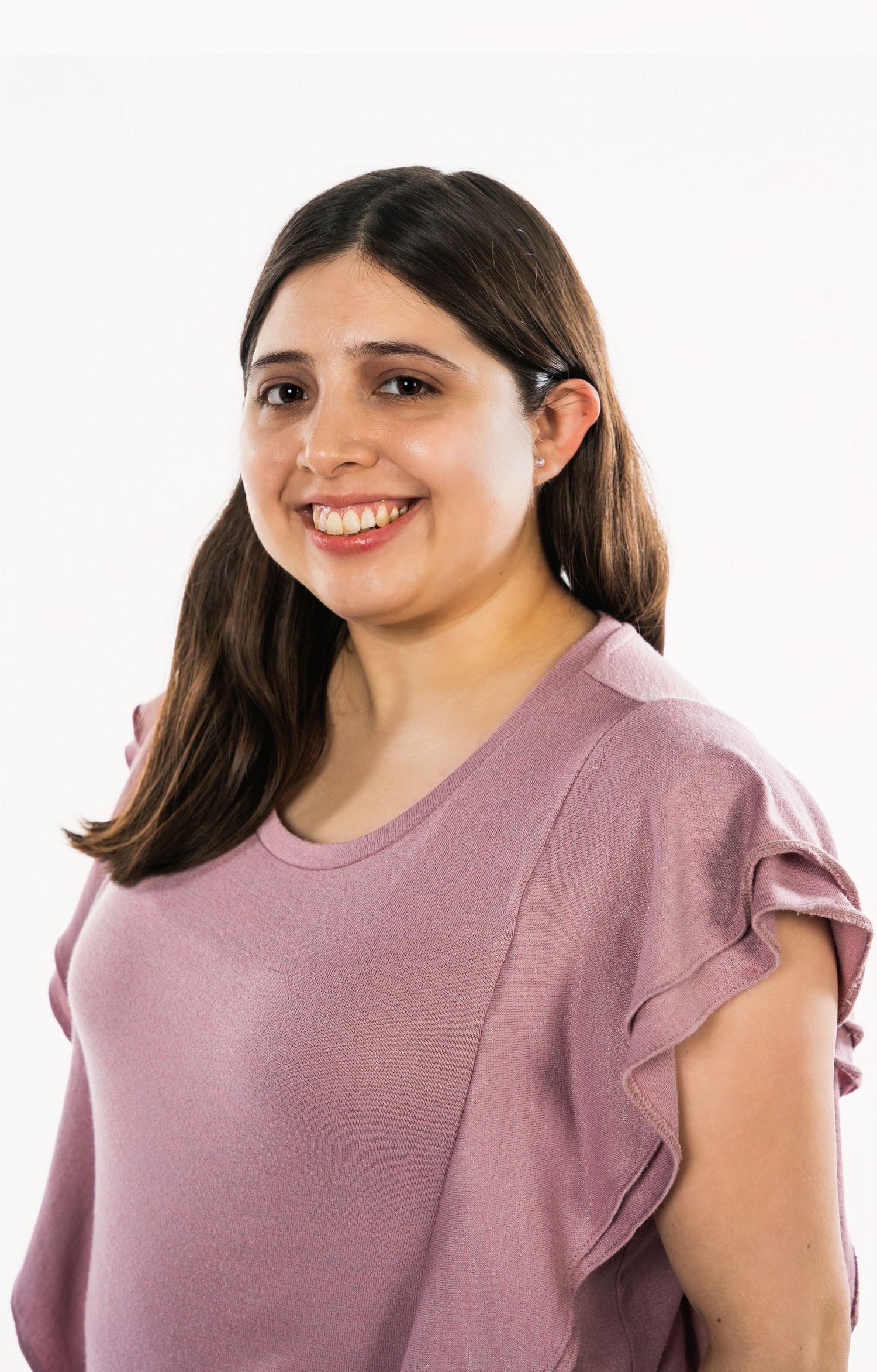 Professional headshot of a woman in a pink ruffled sleeve top against white background.