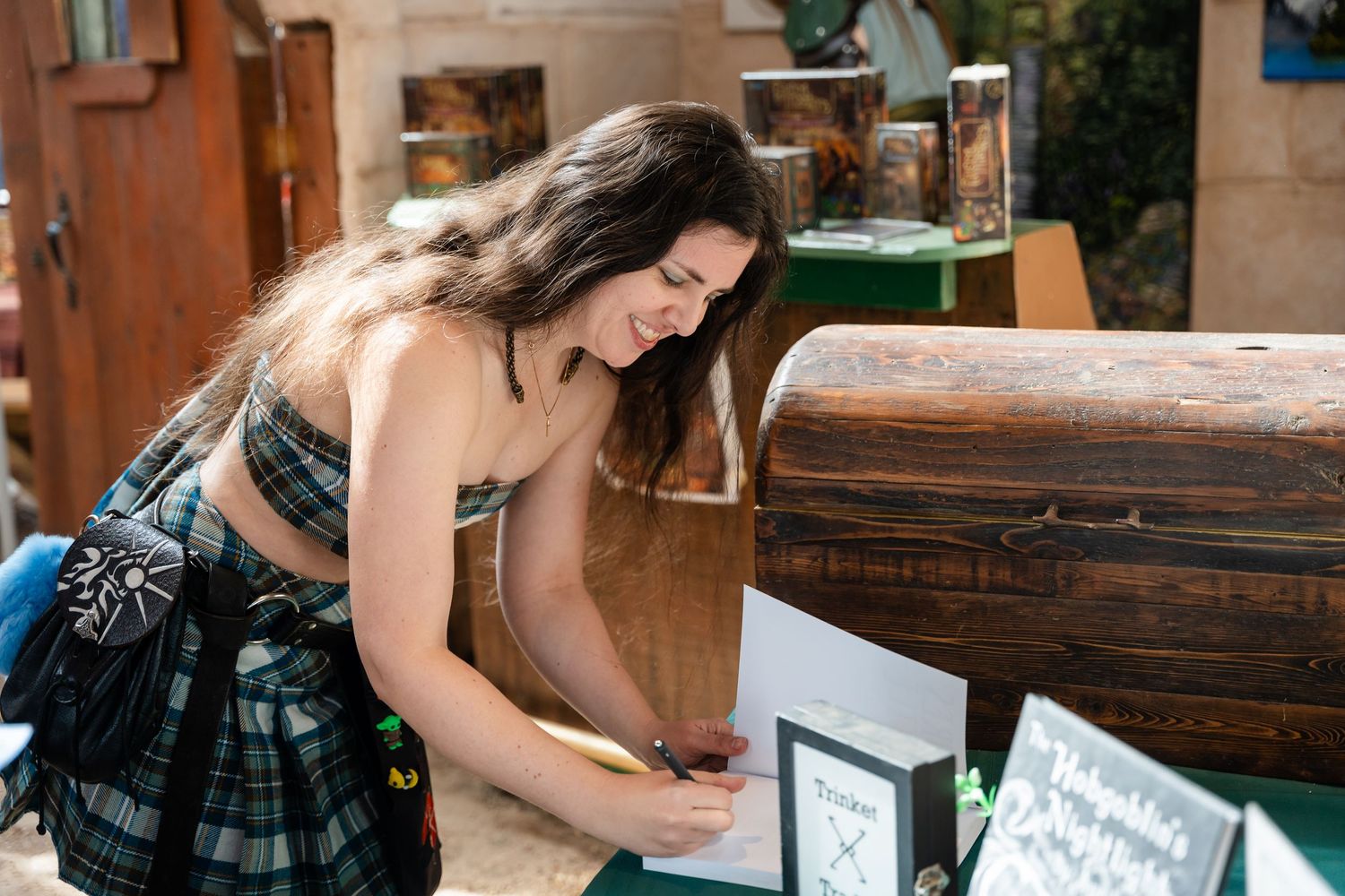 Couple signing wedding documents at a wooden table during their marriage ceremony.