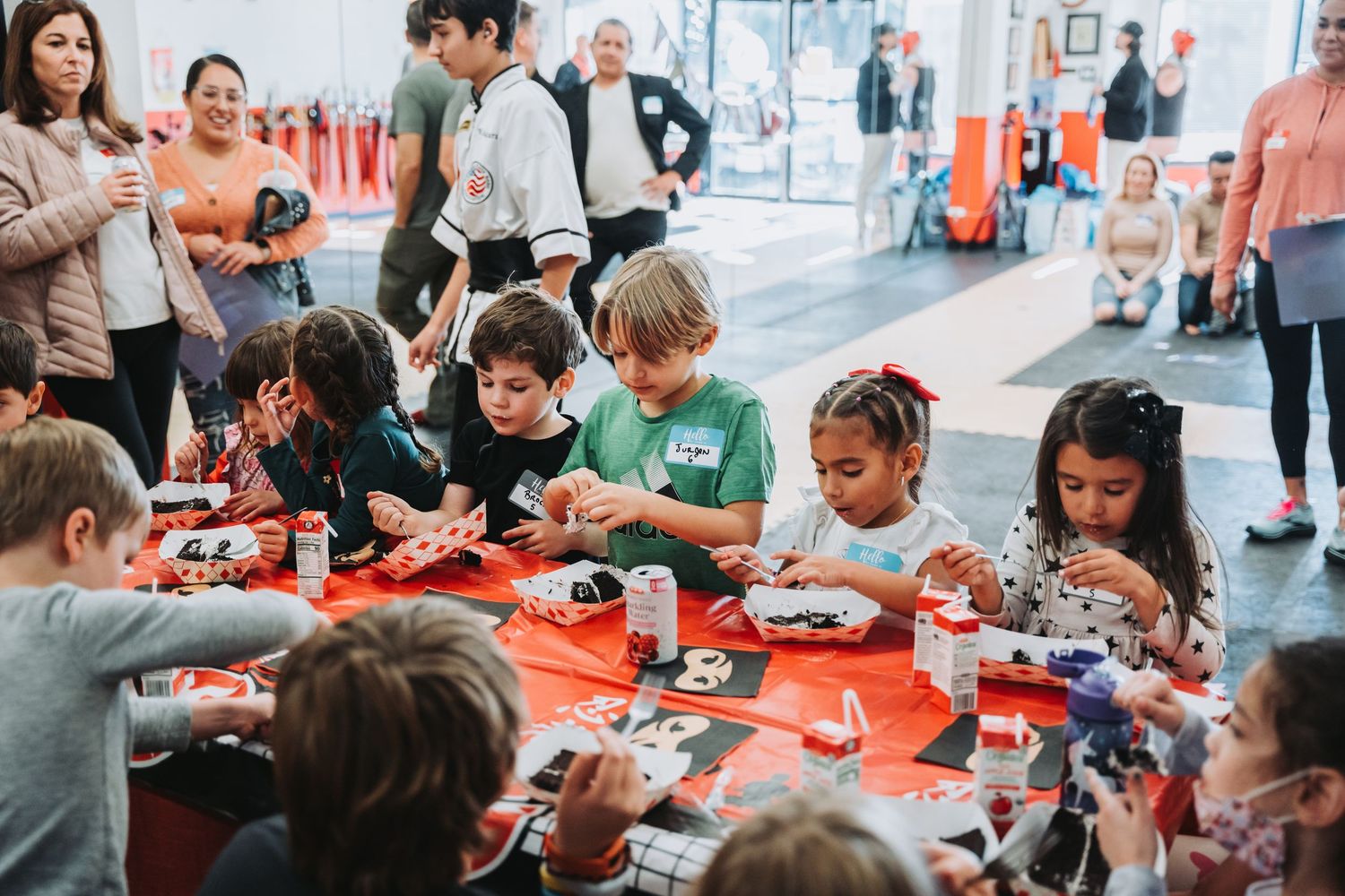 Students work together at tables with electronics and learning materials during a hands-on STEM workshop.