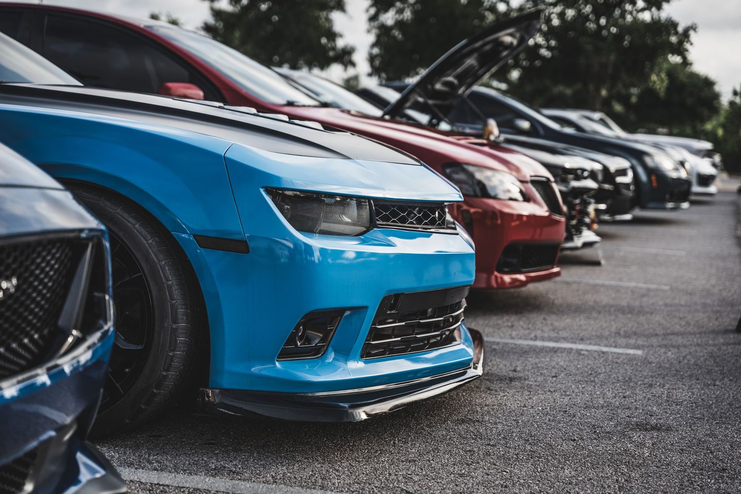 Close-up view of modern sports cars lined up showing their aggressive front ends.