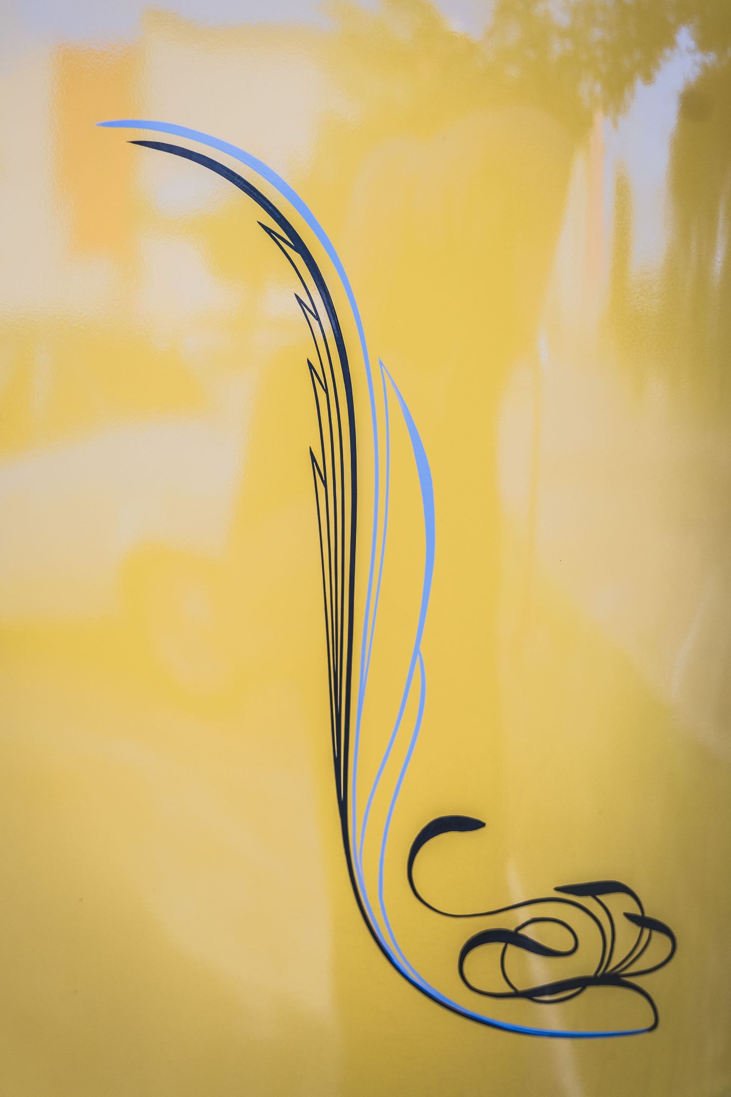 Abstract curved pinstripe design in blue and black on yellow background.