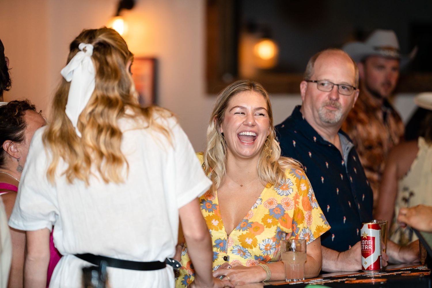 Candid moment of laughter during a social gathering at a bar.