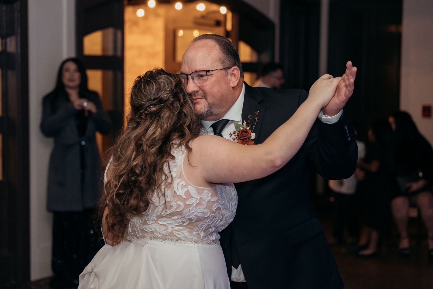 Couple dancing gracefully during their wedding celebration in a beautifully lit venue.