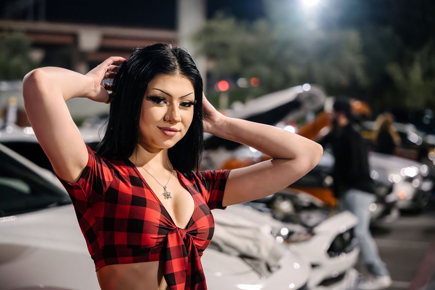 Red buffalo plaid crop top fashion shoot with cars in background at night.