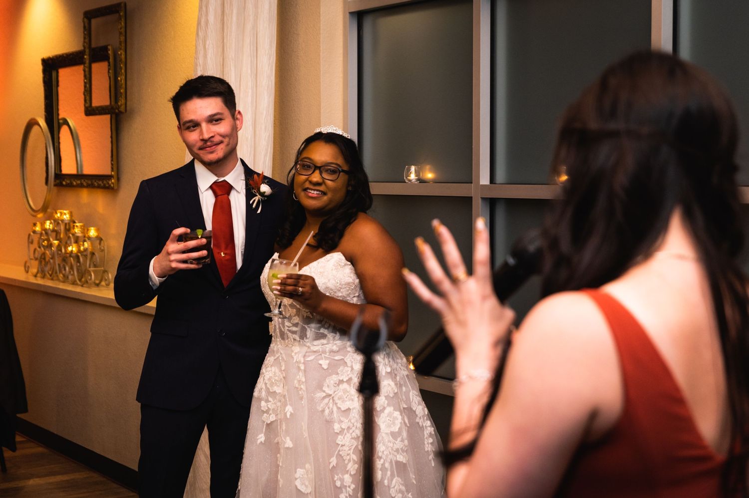Wedding reception scene with couple toasting while guests celebrate.