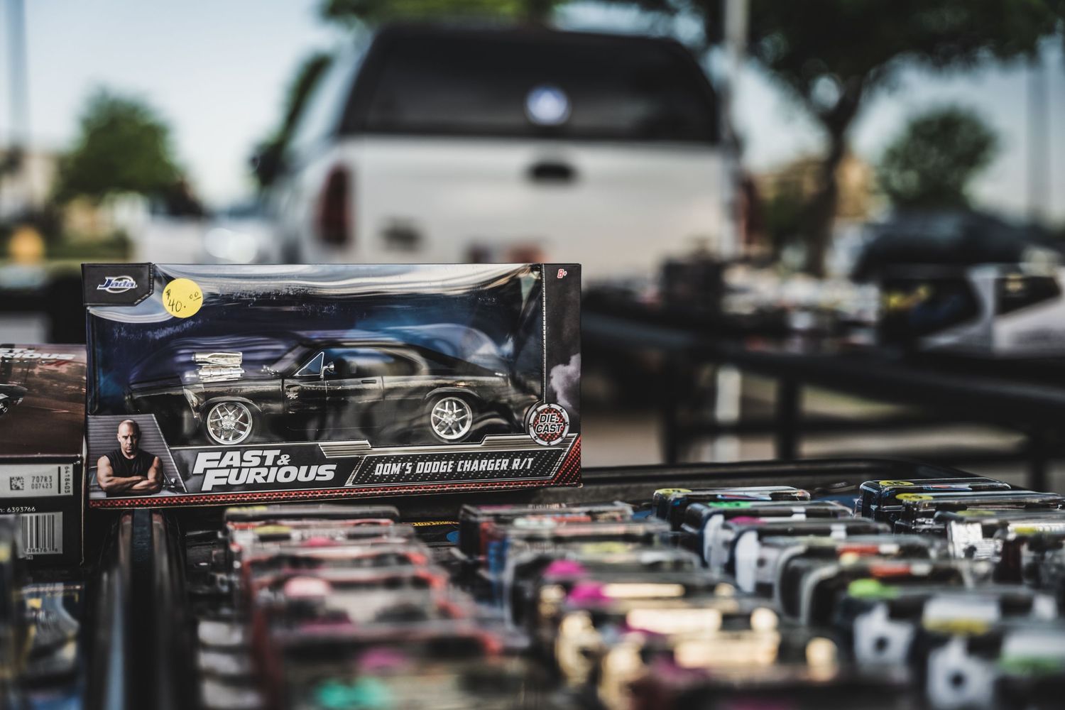 Close-up shot of Fast and Furious model cars displayed for sale at outdoor market.