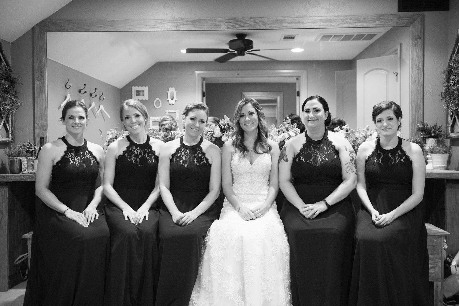 A formal wedding party portrait in black and white featuring matching dark dresses.