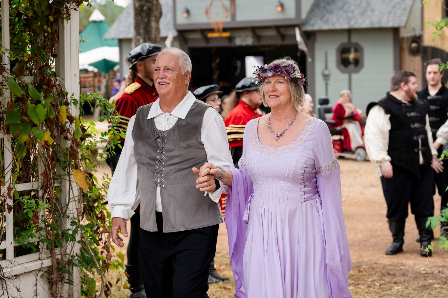 Wedding guests in purple dresses celebrate during an outdoor garden reception ceremony.