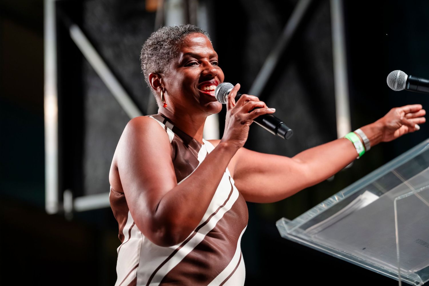 Energetic performer singing passionately on stage with dramatic lighting and microphone in hand during live concert.