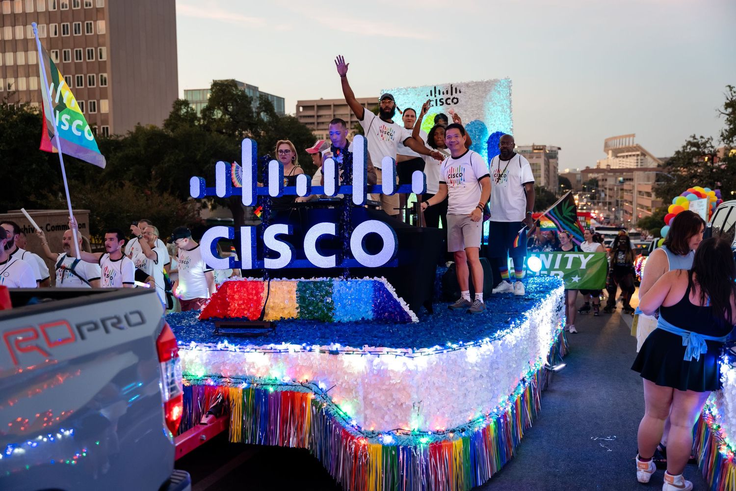 Cisco Pride parade float with colorful LED lights and rainbow decorations, featuring employees celebrating diversity.