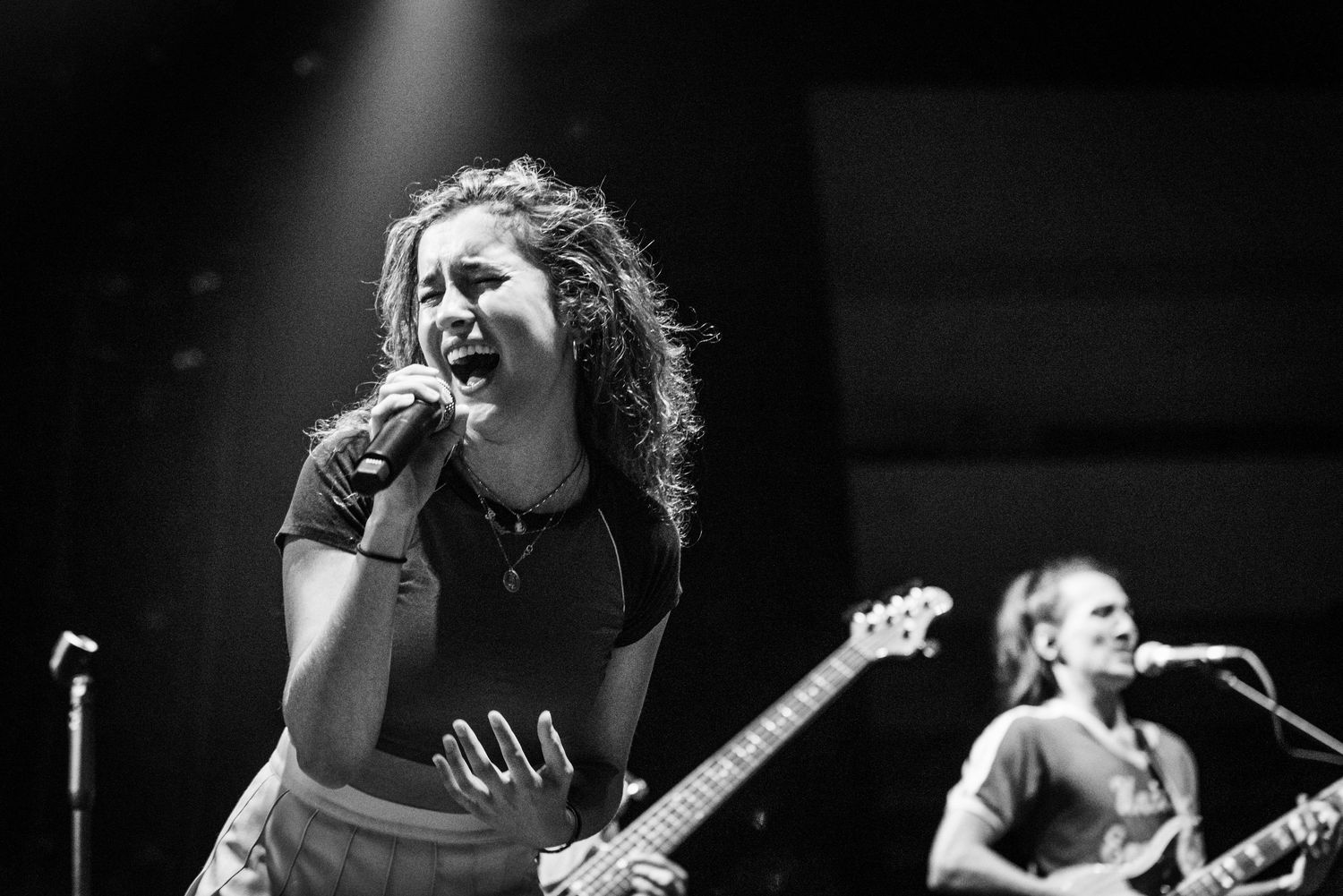 A black and white photo montage shows performers singing and playing instruments on stage during a live concert.