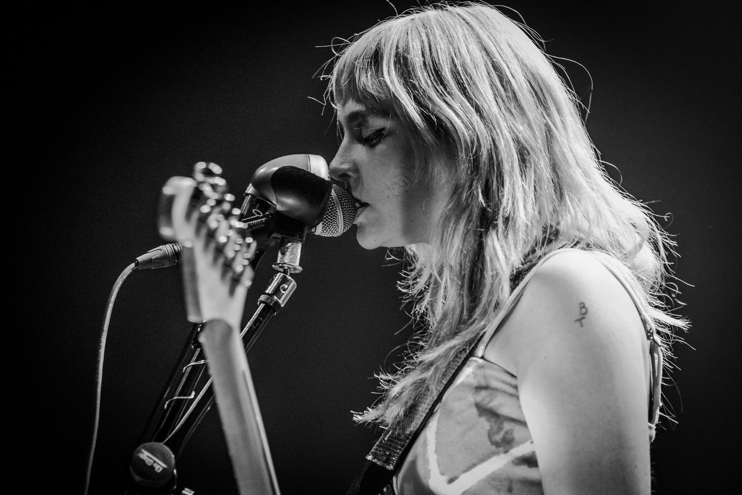 Black and white concert photo sequence showing an energetic performer with flowing hair singing into a microphone.