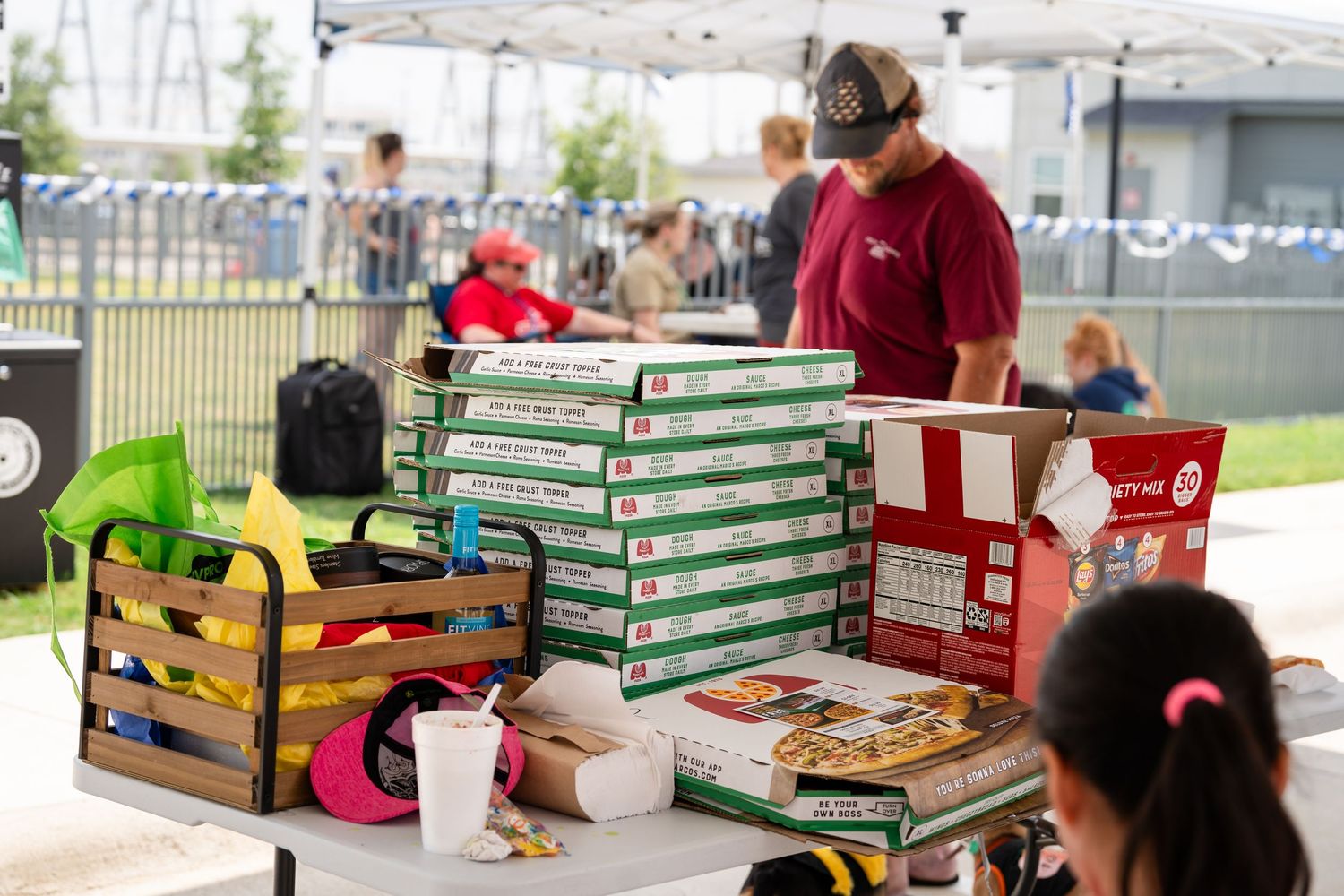 Colorful pet supplies and toys displayed on vendor table at outdoor event.