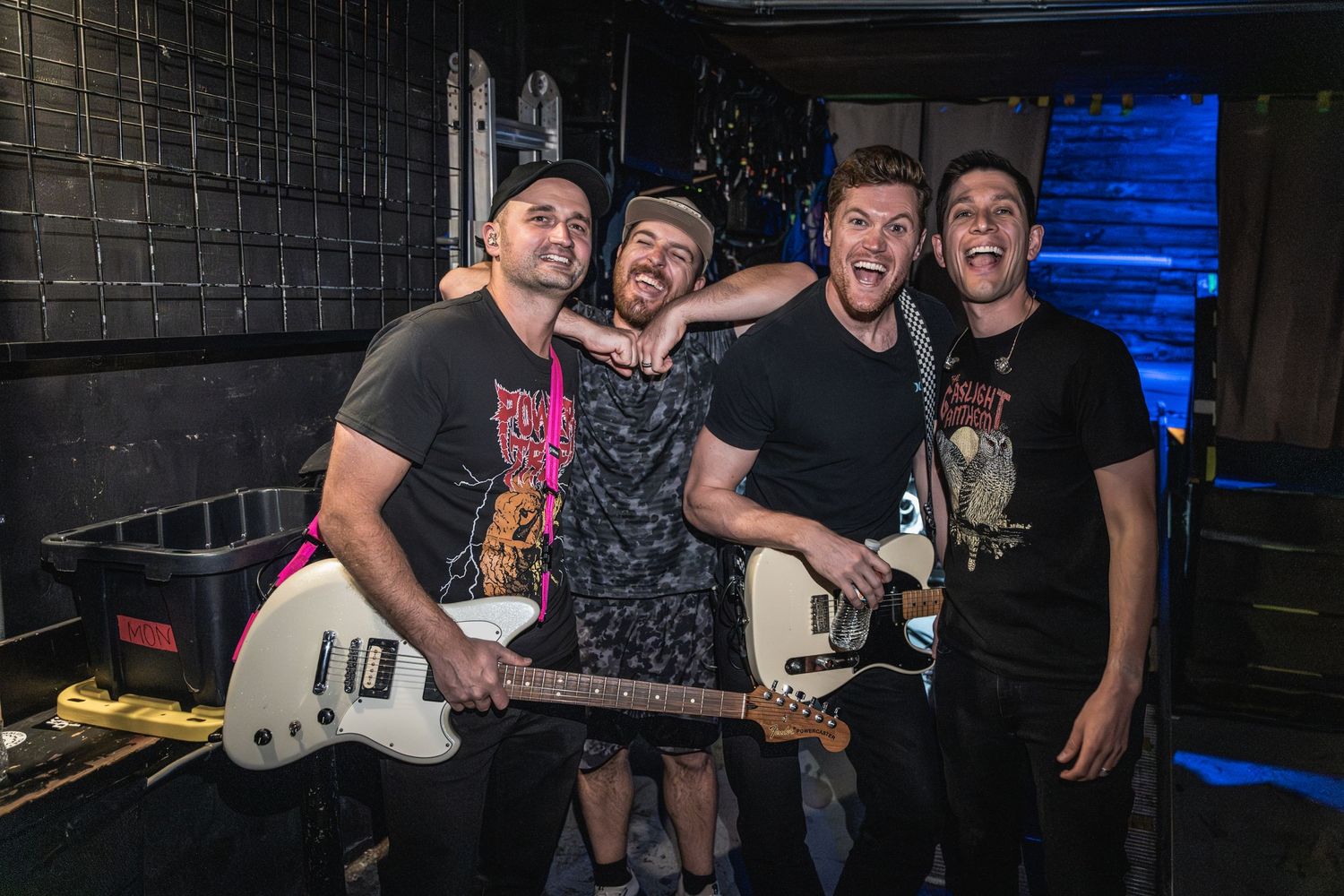 Musicians posing backstage with instruments after a performance.