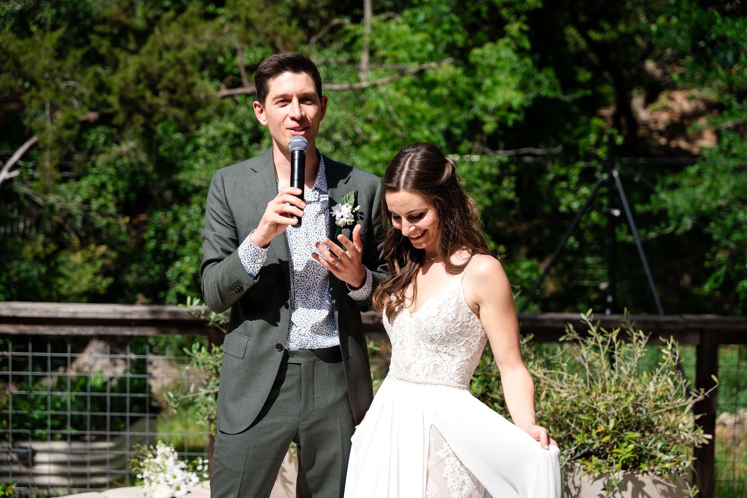 A couple enjoying drinks during their wedding celebration in an outdoor garden setting.