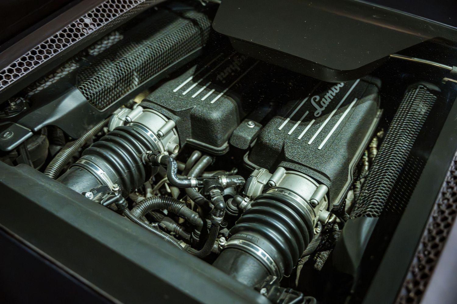 Close-up detail shot of a performance car engine bay showing dual intake manifolds.