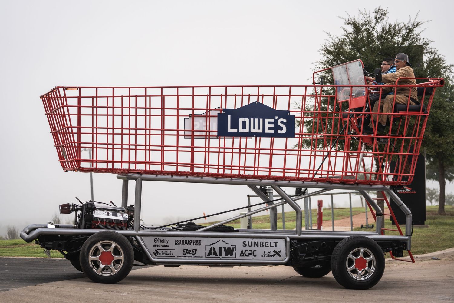 A custom-built shopping cart vehicle displaying the Lowe's logo on a trailer chassis.