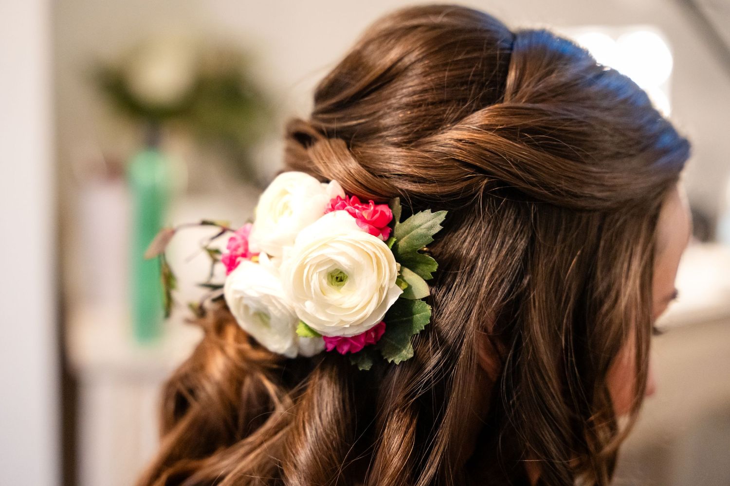 Beautiful floral hair piece with pink and white flowers adorns a brunette hairstyle.