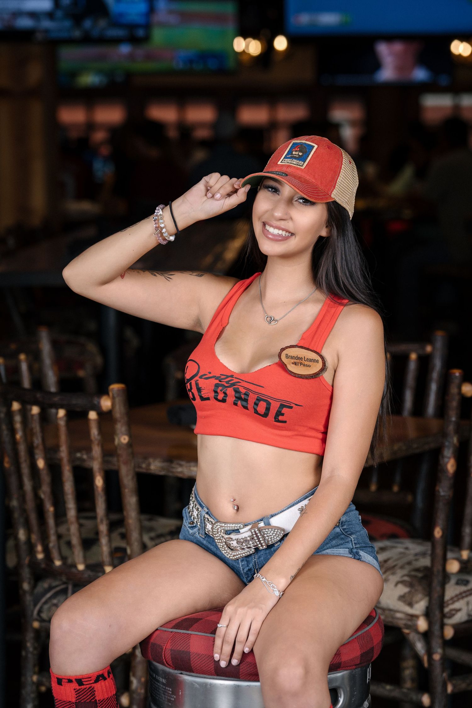Sports bar promotional photo with casual attire and branded merchandise.