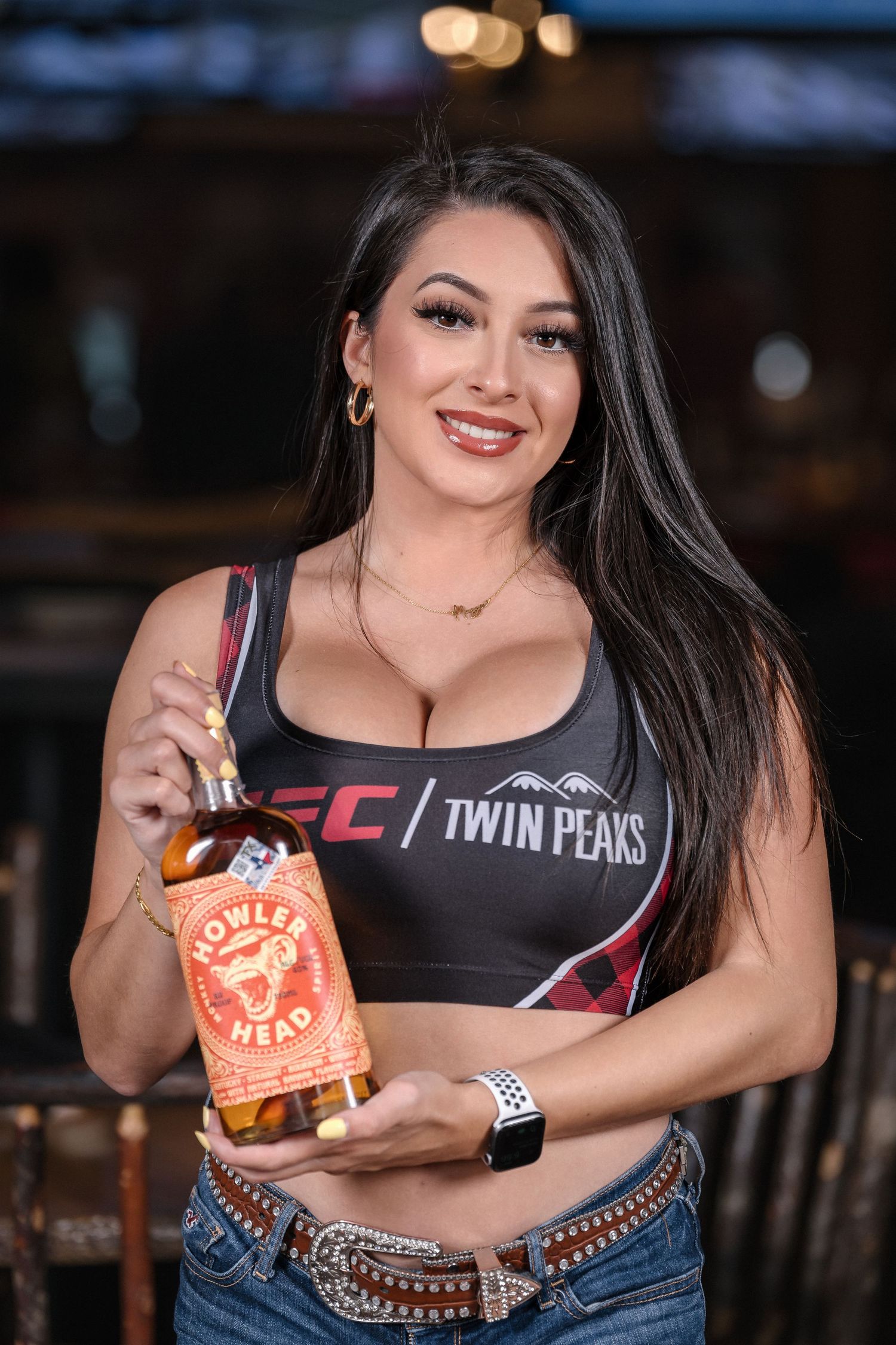 Twin Peaks promotional photo with branded tank top and bourbon bottle.
