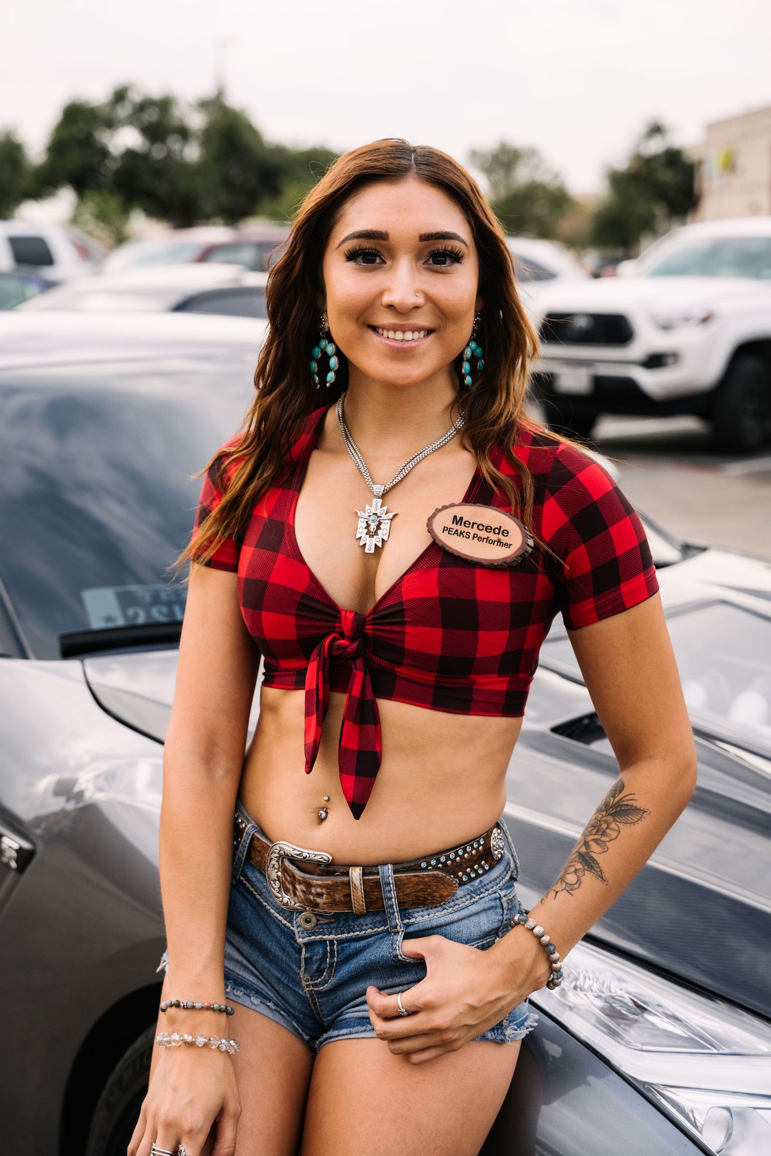 A red plaid crop top and denim shorts outfit shown in a parking lot setting.