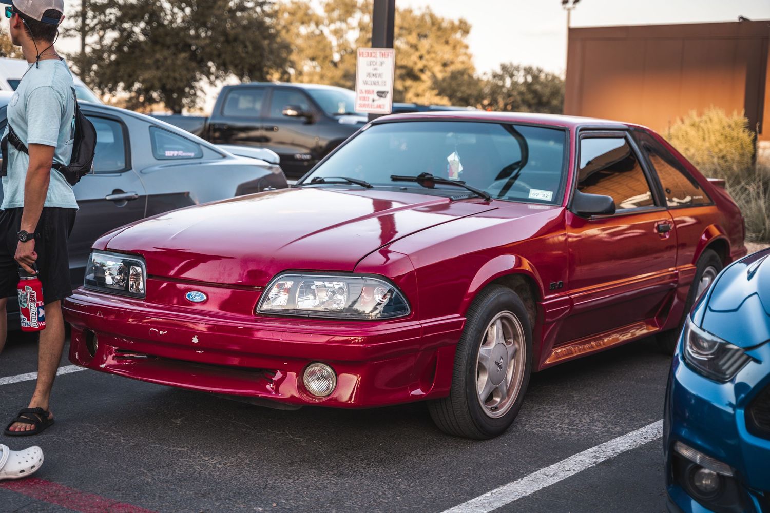 Candy red Ford Mustang Fox Body in pristine condition at a car meet.