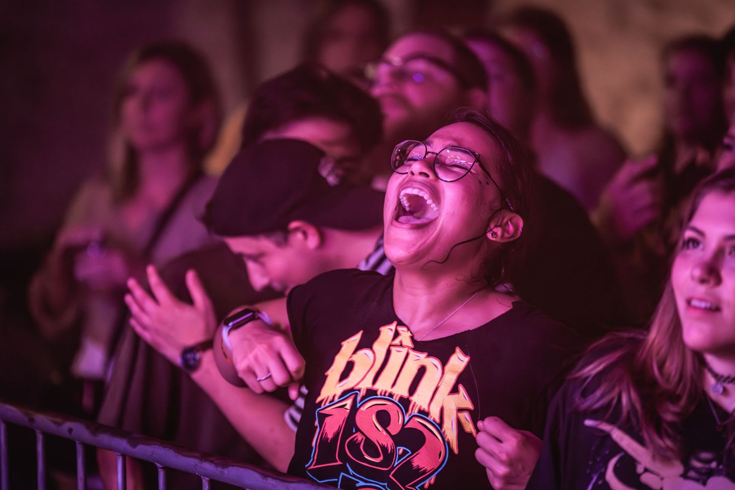 Excited fans react with joy during live concert performance.