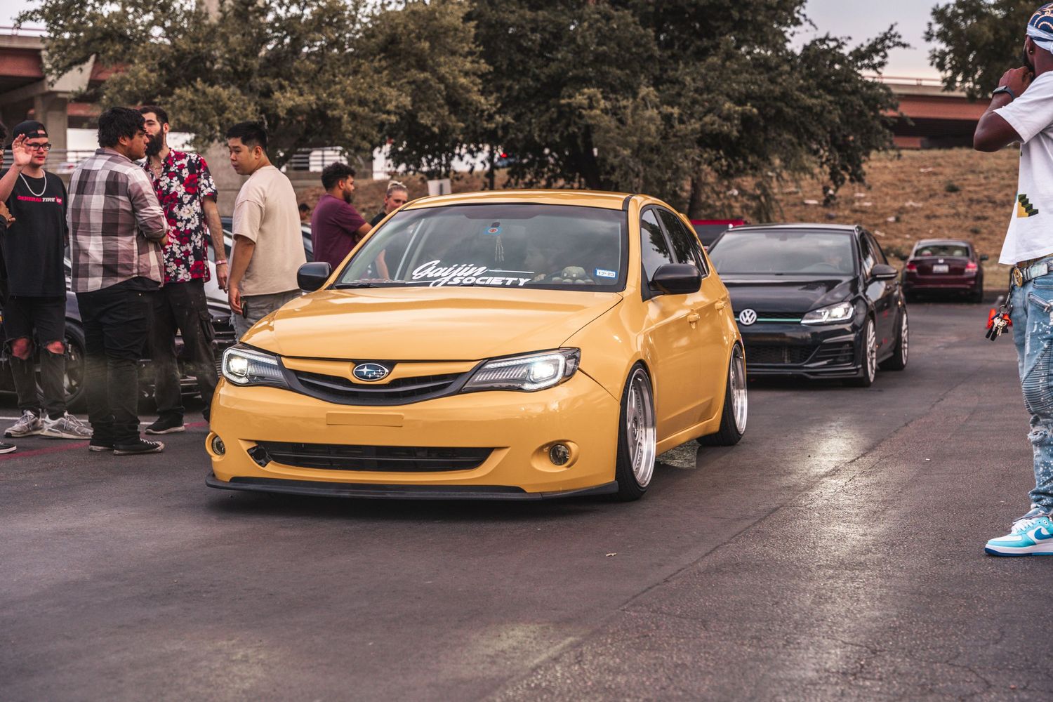 Custom yellow Subaru lowered stance car at automotive meet.